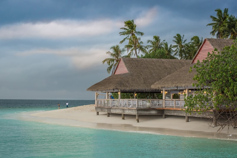 A luxurious private villa with an infinity pool overlooking a spectacular tropical sunset over the ocean